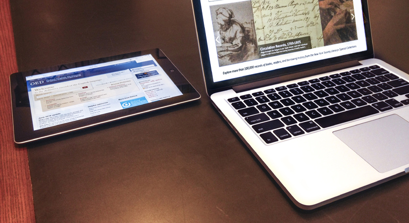 An iPad and a laptop side by side on a desk.